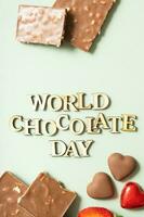 World chocolate day text with chocolate flat lay, top view on pastel green background photo