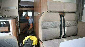 ouvrier nettoyage RV camping car intérieur en utilisant vide video