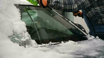 hombres quitando nieve desde su vehículo y deshielo parabrisas. video