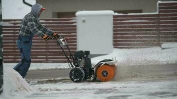 ouvrier enlever neige et la glace en utilisant de l'essence brosse balai video