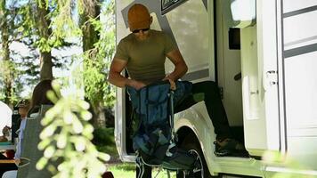 Caucasian Man in His 40s Preparing His Backpack For a Hike STanding Next to His Camper Van RV video