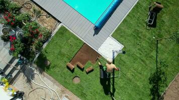 Landscaping Worker Rolling Out Turf Rolls in a Garden Aerial View video