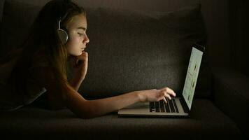 menina com fones de ouvido e dela computador relaxante em alguns cama video