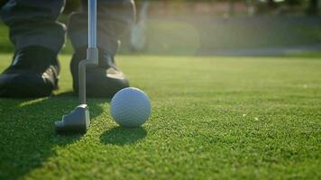 golf spelare använder sig av putter klubb göra en stroke med de avsikt av rullande de boll in i de hål. golf turnering. video