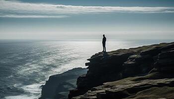 Young adult conquering adversity, standing on cliff, looking at view generated by AI photo