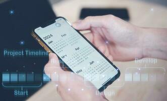Concept of time management financial planning and reminder for 2024. man using smartphone working with calendar 2024, business planning marketing and investment, schedule appointment meeting photo