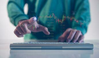 financial investment concept, businessman typing on computer keyboard  touching virtual trading graph buy and sell share in concept of investment business growth and marketing photo
