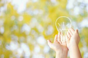 two hand of young business man open hand with blub light sketch of idea on blur background photo