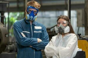 emergency pollution factory concept. Portrait engineer wearing a mechanical jumpsuit and gas mask looking at the camera with his arms crossed. photo