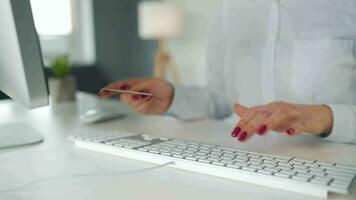 mujer mecanografía crédito tarjeta número en computadora teclado. ella haciendo en línea compra. en línea pago Servicio video