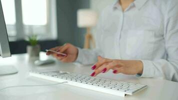 mujer mecanografía crédito tarjeta número en computadora teclado. ella haciendo en línea compra. en línea pago Servicio video