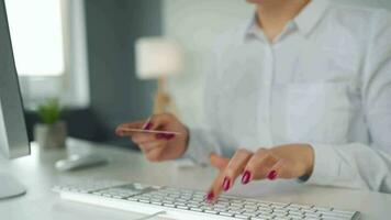 mujer mecanografía crédito tarjeta número en computadora teclado. ella haciendo en línea compra. en línea pago Servicio video