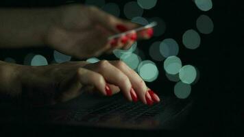 Female hands is typing on a laptop at night. Blurred lights on the background video