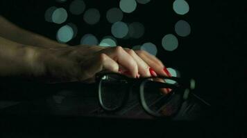 kvinna händer är skriver på en bärbar dator på natt. suddig lampor på de bakgrund video