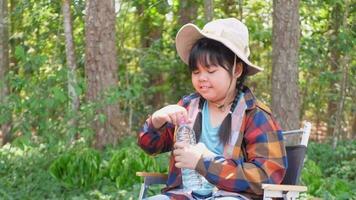 asiatique fille séance en dessous de le arbre souriant Heureusement video