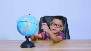 Asian boy looking at world map video