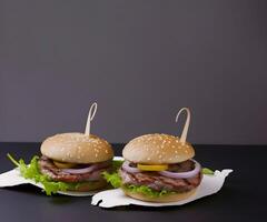 Two hamburgers with delicious ingredients sorted on table. photo