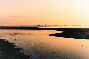 Silhouette of family playing on the beach at sunset. photo