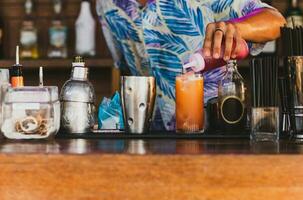 Bartender making cocktail topping with grenadine syrup at the bar. photo