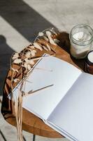 revista y libro Bosquejo diseño. blanco revista en moderno de madera mesa con velas , sombra cubrir foto