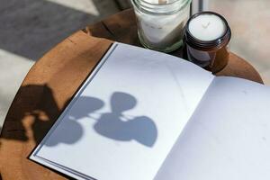 Magazine and book mockup design. Blank magazine on modern wooden table with candles , shadow overlay photo