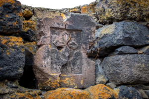 Close up stone cross on rough stone wall concept photo. Historical tombs png