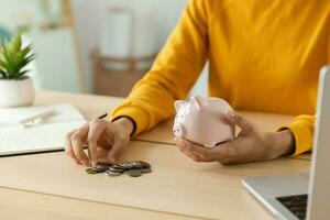 Saving money investment for future. Female woman hands holding pink piggy bank and putting money coin. Saving investment budget business wealth retirement financial money banking concept. photo