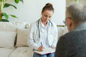 Female doctor examining older senior man in doctor office or at home. Old man patient and doctor have consultation in hospital room. Medicine healthcare medical checkup. Visit to doctor. photo