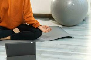 Yoga mindfulness meditation. Woman hands in chin mudra gesture. African girl practicing yoga at home. Woman sitting in lotus pose on yoga mat meditating relaxing indoor. Girl doing breathing practice. photo