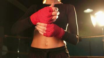 mujer yo defensa niña fuerza. mujer combatiente preparando para lucha envase manos con rojo boxeo envuelve Deportes protector vendajes, fuerte manos Listo para lucha activo ejercicio combate rutina de ejercicio formación foto