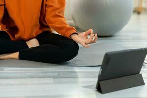 Yoga mindfulness meditation. Woman hands in chin mudra gesture. African girl practicing yoga at home. Woman sitting in lotus pose on yoga mat meditating relaxing indoor. Girl doing breathing practice. photo