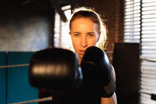 mujer yo defensa niña fuerza. fuerte mujer combatiente puñetazos con boxeo guantes a cámara. sano fuerte niña puñetazos formación puñetazos mirando concentrado derecho. ajuste cuerpo ejercicio. foto