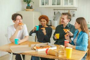 hogar fiesta. lleno de alegría diverso amigos comiendo ordenado Pizza para hogar fiesta. contento grupo mezclado carrera joven amigos disfrutando gasto gratis fin de semana hora juntos teniendo divertido riendo bromas comunicado. foto