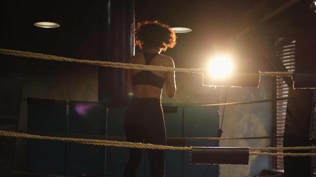 mujer yo defensa niña fuerza. africano americano mujer combatiente formación puñetazos en boxeo anillo. sano fuerte niña puñetazos boxeo bolsa. formación día en boxeo gimnasia. fuerza ajuste cuerpo rutina de ejercicio capacitación. foto