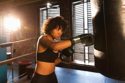 mujer yo defensa niña fuerza. africano americano mujer combatiente formación puñetazos en boxeo anillo. sano fuerte niña puñetazos boxeo bolsa. formación día en boxeo gimnasia. fuerza ajuste cuerpo rutina de ejercicio capacitación. foto