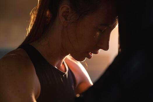 mujer yo defensa niña fuerza. fuerte mujer combatiente descansando después lucha formación en boxeo anillo. fuerte niña cansado después puñetazos boxeo bolsa. formación día en gimnasia. fuerza ajuste cuerpo rutina de ejercicio capacitación. foto
