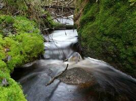 cold stream flows among huge boulders long exposure photo