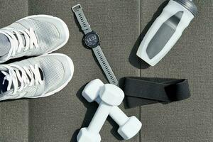 Sneakers and sport items on gray background top view photo