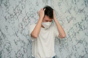 Man puts on a face mask headache isolated on White background,pandemic and social distancing concept.Covid-19 photo