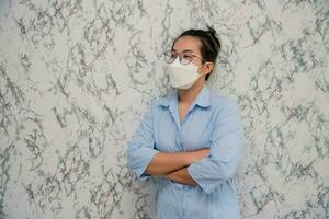 Woman puts on a face mask standing with crossed arms protecting from virus during quarantine isolated on White background,pandemic and social distancing concept photo