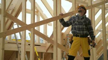 lavoratore guardare su su il tetto luogo di di legno scheletro struttura video