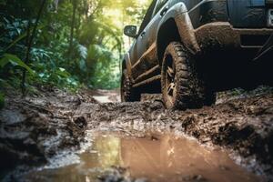 Four wheel drive SUV is driving on muddy road in jungle. photo