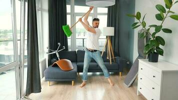 Man cleaning the house and having fun dancing with a broom. Slow motion video