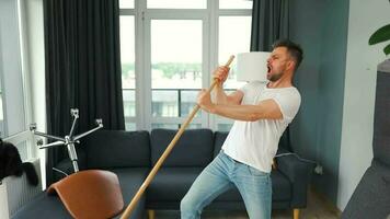 hombre limpieza el casa y teniendo divertido bailando con un escoba. lento movimiento video