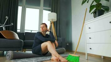 Woman sits in the middle of the room deep in thought. She needs to clean up, but she procrastinates video