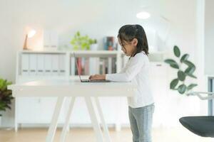 A girl using a computer keyboard while. photo