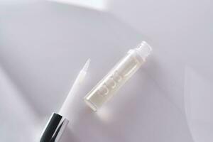 A pack of brow gel or clear lip gel in a pack with a brush. photo