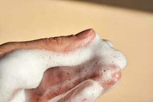 Photo of the texture of cosmetic foam on the hand.