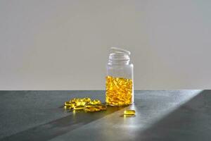 A jar of OMEGA 3 capsules stands on a dark table. photo