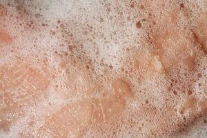 Photo of the texture of cosmetic foam or soap on the hand.